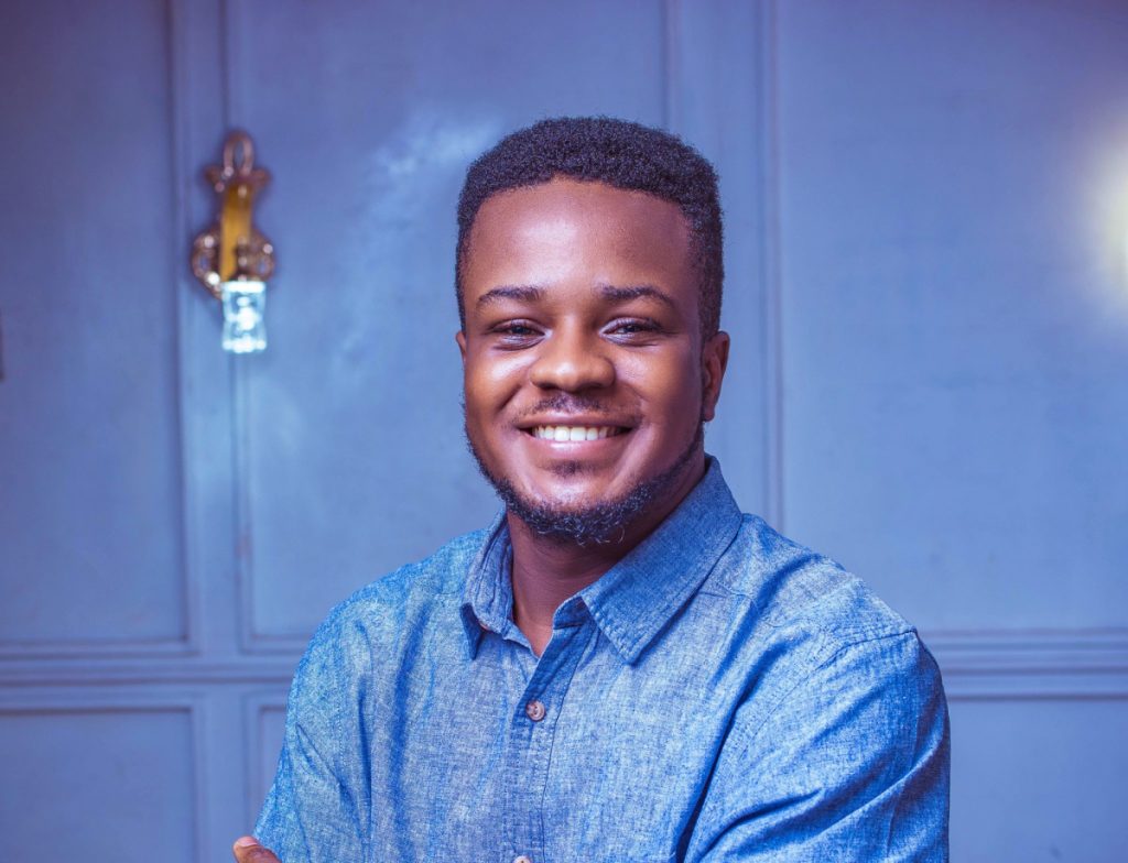 Image of Stanley Anigbog in a blue shirt smiling at the camera